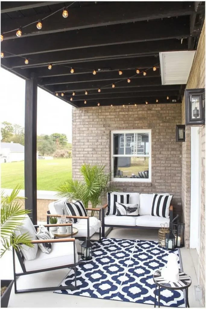 20 Dreamy Outdoor Escapes Cozy Patios and Pergola Ideas 39 16. Monochrome Covered Porch with Edison Bulbs and Palms