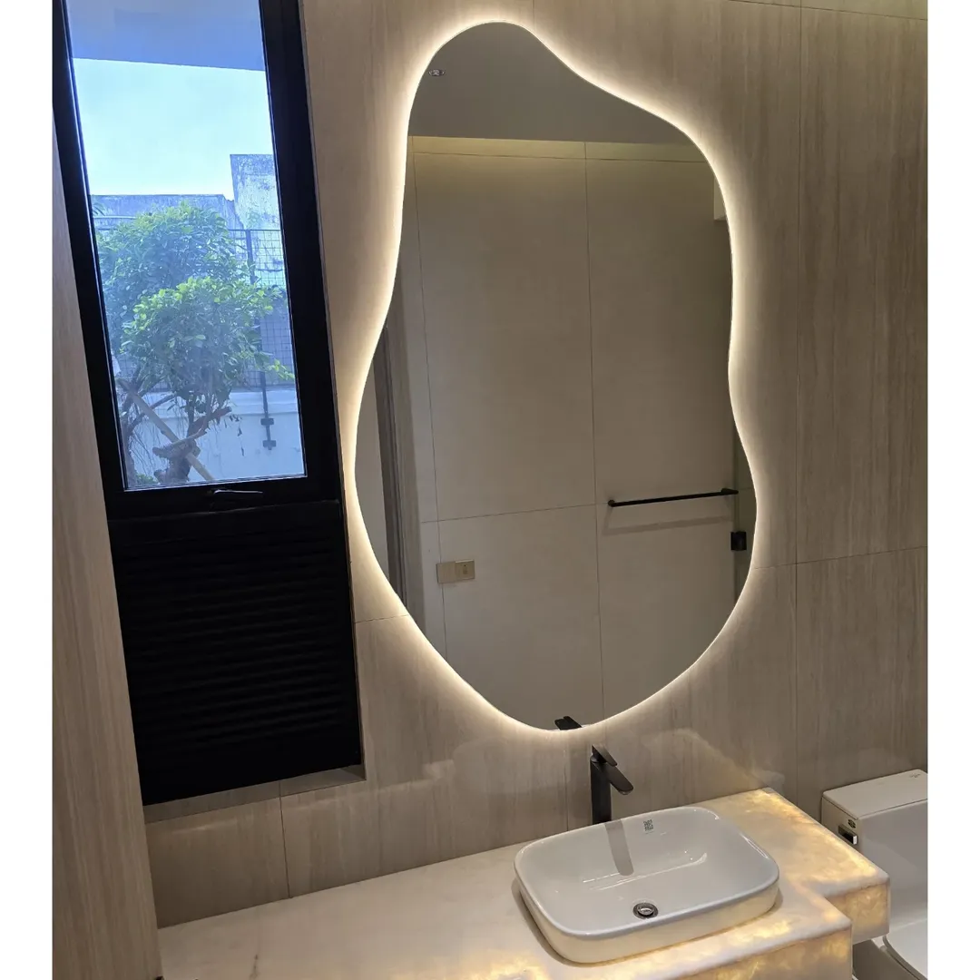 Custom organic shaped backlit mirror designed for modern washrooms. DM call or visit our websi