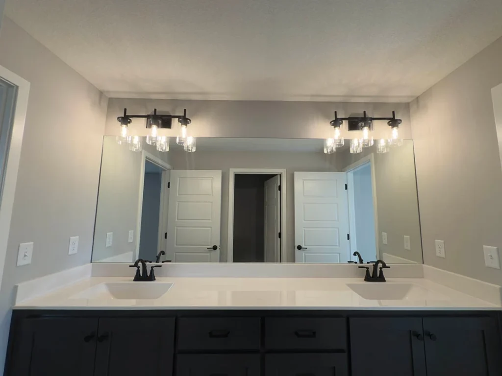This oversized custom mirror makes the bathroom feel so much brighter bigger and perfect for t